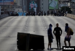 Demonstrators are seen with the security forces behind them during a protest against Venezuelan President Nicolas Maduro's government in Caracas, Venezuela, Feb. 2, 2019.