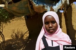Manasik Yousif Abdo-Rahman, a 4th grader at the Alsalam camps for the internally displaced persons poses for a photograph in El-Fasher in North Darfur, Sudan, Nov.17, 2015.