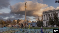 资料照片：在基辅独立广场，穿着军服的行人走过纪念阵亡乌克兰军人的旗帜。(2023年10月23日)