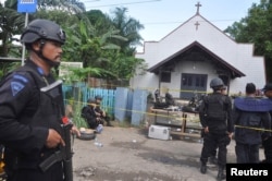 FILE - Police stand near the scene of an explosion outside a church in Samarinda, East Kalimantan, Indonesia, Nov. 13, 2016.