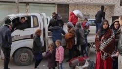 Syrians flee their homes in the Ghwayran neighborhood in the northern city of Hasakeh on Jan. 23, 2022, on the fourth day of fighting between the Kurdish forces and Islamic State (IS) group fighters.