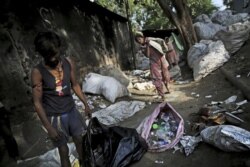 In this Sept. 26, 2019 file photo, Indian rag-pickers collect plastic bottles in New Delhi, India. India is launching an ambitious campaign to eliminate single-use plastics within three years.