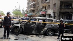 FILE - Policemen secure the site of a car bomb attack on the convoy of Egyptian public prosecutor Hisham Barakat near his house at Heliopolis district in Cairo, Egypt, June 29, 2015. 