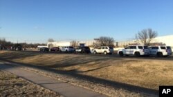 In this photo provided by KWCH-TV, police vehicles line the road after reports of a shooting at an industrial site in Hesston, Kan., Feb. 25, 2016. 