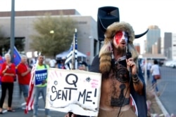 FILE - Jacob Anthony Chansley, who also goes by the name Jake Angeli, a QAnon follower, speaks to supporters of then-President Donald Trump outside of the Maricopa County Recorder's Office, in Phoenix, Nov. 5, 2020.
