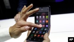 A Samsung worker gives a demonstration of the Galaxy Z Flip Phone at the Unpacked 2020 event in San Francisco, Tuesday, Feb. 11, 2020.