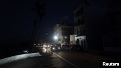 Cars drive on a street in the light of a generator-powered lamp set up by the municipality, after Hurricane Maria hit the island and damaged the power grid in September, in Old San Juan, Puerto Rico Oct. 26, 2017.