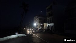 Cars drive on a street in the light of a generator-powered lamp set up by the municipality, after Hurricane Maria hit the island and damaged the power grid in September, in Old San Juan, Puerto Rico Oct. 26, 2017.