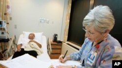 Susan Deautremont, R.N., right, charts information while caring for Sherry Webb, left, at the Sickle Cell Center in Truman Medical Center, March 7, 2007, in Kansas City, Mo.