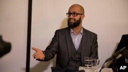 FILE - CAGE research director, Asim Qureshi talks, during a press conference held by the CAGE human rights charity in London, Feb. 26, 2015. 