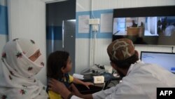 FILE - A Pakistani paramedic checks a child at a telemedicine center run by the government of Khyber Pakhtukhwa in the remote Behali area, Oct. 20, 2017. Singapore has introduced telemedicine legislation as part of its Healthcare Services Act 2020.
