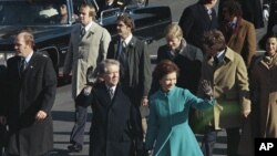 FILE - This Jan. 20, 1977 file photo shows President Jimmy Carter and First Lady Rosalynn Carter waving as they walk down Pennsylvania Avenue in Washington after Carter was sworn in as the nation's 39th president.