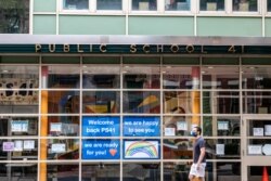A pedestrian walks past Public School 41 following the outbreak of the coronavirus disease, New York.