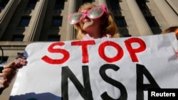 Poster anti program pengintaian NSA yang dipasang oleh kelompok protes Code Pink di depan gedung Departemen Kehakiman, Washington.