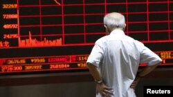 វិនិយោគិន​ម្នាក់​កំពុង​សម្លឹង​មើល​ផ្ទាំង​ព័ត៌មាន​អំពី​ផ្សារភាគហ៊ុន​ នៅឯ​ការិយាល័យឈ្មួញ​កណ្តាល​មួយ​ ក្នុង​ទីក្រុង​ប៉េកាំង​ ប្រទេសចិន កាលពីថ្ងៃទី៧ ខែ​កក្កដា ឆ្នាំ២០១៥។