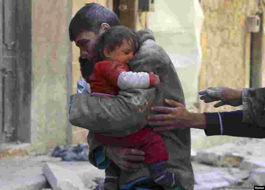 A boy holds his baby sister, who survived what activists say was an airstrike by forces loyal to Syrian President Bashar al-Assad in Aleppo, Feb. 14, 2014.