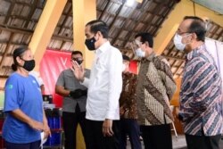 Presiden Jokowi berbincang dengan salah satu penerima vaksin di Pasar Beringharjo, Yogyakarta. (Foto: Courtesy/Humas Pemda DIY)