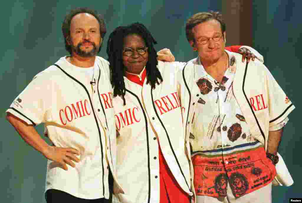 Komedian Robin Williams (kanan), Billy Crystal (kiri) dan Whoopi Goldberg saling merangkul di panggung Radio City Music Hall, New York di akhir acara &quot;Comic Relief 8&quot; HBO, 14 Juni 1998. Mereka menjadi pembawa acara yang mengumpulkan dana untuk proyek tunawisma di lebih dari 20 kota-kota Amerika.