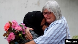 Women embrace near Masjid Al Noor mosque in Christchurch, New Zealand, March 17, 2019. 