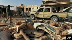 Para kombatan milis Kataeb Hezbollah atau Brigade Hezbollah, memeriksa kerusakan pada markas mereka setelah serangan udara di Qaim, Irak, 30 Desember 2019. 