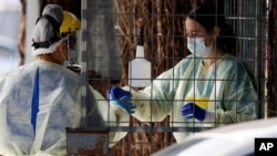 Petugas medis mempersiapkan test COVID-19 untuk warga secara drive thru di kota Christchurch, Selandia Baru (13/8). 