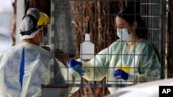 Medical staff prepare to take a COVID-19 tests at a drive through community based assessment centre in Christchurch, New Zealand, Aug. 13, 2020.