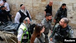 نیروهای اورژانس اسرائیل جسد مهاجم را که به گفته پلیس اسرائیل، شهروند ترکیه است حمل می‌کنند - ۱۱ اردیبهشت ۱۴۰۳