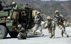 FILE - U.S. Army and South Korean soldiers take their positions during a live-fire exercise as a part of the annual joint military exercises, at the Rodriquez Multi-Purpose Range Complex in Pocheon, South Korea, March 25, 2015.