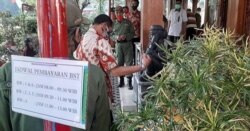 Wali kota Solo, Hadi Rudyatmo (batik merah putih, dua dari kanan) memantau langsung penyerahan bantuan sosial tunai BST dan penerapan protokol kesahatan di Solo, Sabtu (22/8). (Foto: Courtesy/Pemkot Surakarta)