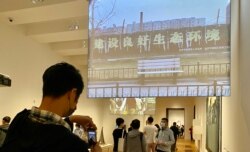 民主派前油尖旺区议员陈嘉朗(拿手机者)在M+博物馆参观艾未未录像作品《长安街》，他认为艺术品不应与国家安全扯上关系 (美国之音/汤惠芸)