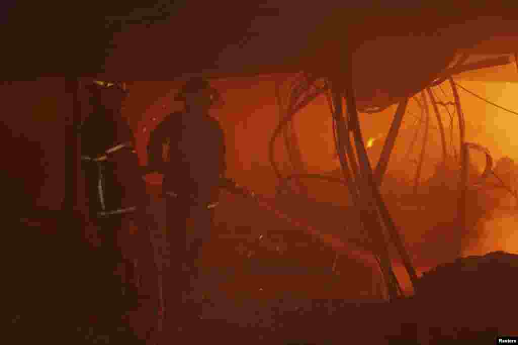 Firefighters try to control a fire inside a garment factory in Gazipur, Bangladesh, Oct. 9, 2013.