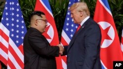 도널드 트럼프 미국 대통령과 김정은 북한 국무위원장이 지난달 12일 싱가포르에서 열린 첫 미-북 정상회담에서 악수하고 있다.