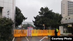 រូបឯកសារ៖ ច្រក​ចូល​មួយ​នៅ​សាកលវិទ្យាល័យ​វូហាន​​ត្រូវ​បាន​បិទ​និង​មាន​ក្រុម​​សន្តិសុខ​ពិនិត្យ​តឹងរ៉ឹង កាល​ពី​ថ្ងៃ​ទី​៣០ ខែ​មករា ឆ្នាំ ២០២០។ (រូបថត​ផ្តល់​ឲ្យ)