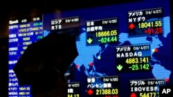 Seorang pria memperhatikan indikator saham elektronik di sebuah perusahaan sekuritas di Tokyo, Jepang, 28 April 2016. (Foto:dok)