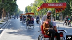 Chinese tourists ride rickshaws for sightseeing in Hanoi, Vietnam, Thursday, Dec. 1, 2016. China tops the list of number of tourists coming to Vietnam. (AP Photo/Tran Van Minh)
