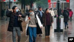 ពលរដ្ឋចិនដើរដោយមានពាក់ម៉ាស នៅទីក្រុងអ៊ូហាន នៃប្រទេសចិន កាលពីថ្ងៃទី២២ ខែមករា ឆ្នាំ២០២០។ 