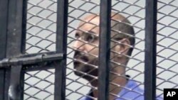 FILE - Saif al-Islam Gadhafi, son of Libya's former stongman Moammar Gadhafi, is shown inside a courtroom cage, Zintan, Sept. 19, 2013.