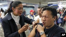 A man is vaccinated against 'swine flu' by a nurse in a subway station in Mexico City (File Photo)
