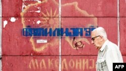 Čovek u Skoplju prolazi pored grafita sa starom mapom Makedonije (Foto: AFP/Robert Atanasovski)