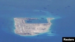 FILE - Chinese dredging vessels are purportedly seen in the waters around Fiery Cross Reef in the disputed Spratly Islands in the South China Sea in this still image taken by a P-8A Poseidon surveillance aircraft, May 21, 2015. 