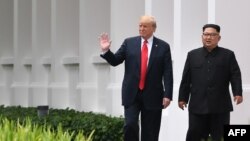도널드 트럼프 미국 대통령과 김정은 북한 국무위원장이 지난 6월 싱가포르 카펠라 호텔에서 오찬을 마친 뒤 함께 산책로를 걷고 있다.