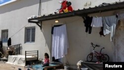 A girl sits outside her family's shelter at the Ritsona camp for refugees and migrants, in Greece, June 15, 2021.