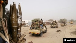 Des soldats tchadiens patrouillent en voiture à travers la ville de Gambaru, Nigeria, le 26 Février 2015.