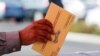 FILE PHOTO: An election worker places a mail-in ballot into an election box at a drive-through drop off location at the Registrar of Voters in San Diego, California