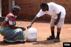 Founder of Urine for Wealth Project Goodfellow Phiri buying urine from a customer in the capital, Lilongwe. (L. Masina/VOA)