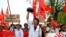 A student carries a monk's alms bowl turned upside down over his head, a Burmese symbol of protest, during a rally against education law in central Yangon, Nov. 17, 2014.
