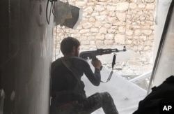 FILE - This undated file photo posted Nov. 4, 2014, by the Raqqa Media Office of the Islamic State group, a militant extremist group, shows an Islamic State fighter in Kobani, Syria.