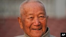 FILE - Nepalese mountain climber Min Bahadur Sherchan, 85, smiles as he finishes his morning yoga workout at his residence in Kathmandu, Nepal, April 12, 2017. Officials said Sherchan died May 6. 