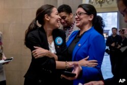 FILE - Rep. Alexandria Ocasio-Cortez, D-N.Y., left, and Rep. Rashida Tlaib, D-Mich., wait for other freshman members of Congress to deliver a letter calling for an end to the government shutdown.
