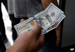 A Turkish man waits to change his U.S. dollars with Turkish liras inside a currency exchange shop in Ankara, Aug. 10, 2018. A financial shockwave ripped through Turkey on Friday as its currency nosedived on concerns about its economic policies and a dispute with the U.S., which President Donald Trump stoked further with a promise to double tariffs on the NATO ally.